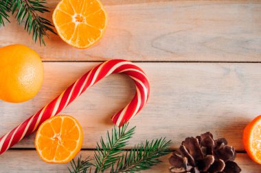 Noel ağacının dekoratif dalları, ahşap arka planda şekerler ve mandallar. Metin için yer.