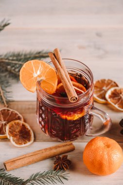 Ahşap arka planda cam bardakta baharatlı sıcak şarap. Noel sıcak içeceği.
