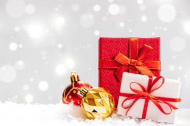 Yeni yıl hediyesi ve arka planda karla kaplı Noel topları. Tatil kartı.