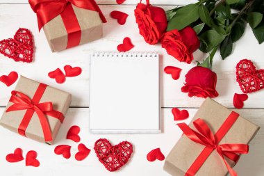 Sevgililer Günü konsepti. Kırmızı güller, kalpler ve beyaz arka planda hediye kutuları. Mokup, metin için yer.