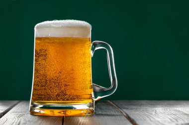 Yeşil arka planda köpüklü bir bardak light bira. Geleneksel İrlanda içkisi. Aziz Patrick gününü kutluyoruz. Metin için yer