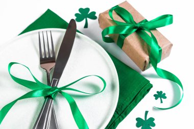 Aziz Patrick Günü için şenlik masası. Tabak ve çatal bıçak takımı yeşil peçeteye. Şansın sembolü yonca..