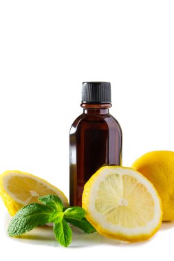 Spa terapisi için kozmetik ürünleri. Beyaz arka planda limonlu ve naneli bir şişe aromatik yağ..