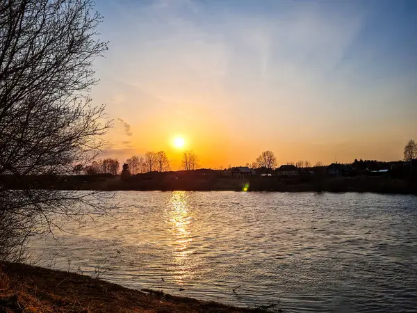 Захід сонця над річкою. Сонце відбивається у воді. Шлях сонячного світла. — стокове фото