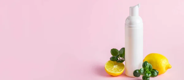 Natural cosmetics for skin care with lemon. Organic beauty product with citrus on a pink background. Place for text.