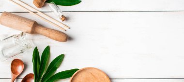 Sıfır atık. Beyaz ahşap arka planda biyolojik olarak bozunabilir mutfak gereçleri. Sancak biçimi