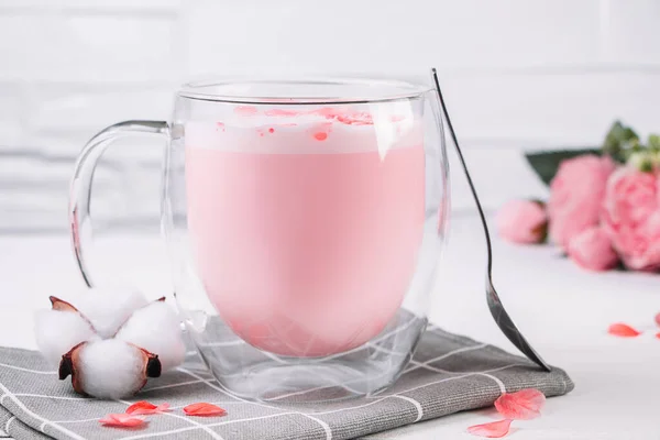 粉红的茶花 花瓣白色背景 透明杯子加时髦的纯素食泡茶 月球牛奶 睡觉时放松饮料 — 图库照片