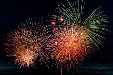 Siyah arka planda parlak renkli havai fişekler. Kutlama ve tatil konsepti. Yeni yıl, Bağımsızlık Günü, 4 Temmuz Festivali. Gökyüzündeki parlak ışık patlamaları.
