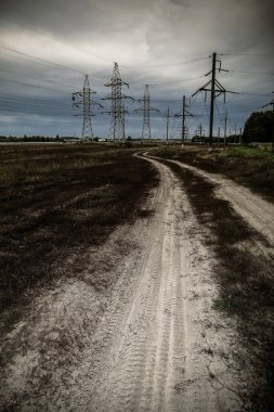 Bulutlu bir günde elektrik hattı. Yüksek voltajlı elektrik kuleleri. Sanayi manzarası.