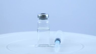 Ampul, aşı ve beyaz arka planda tıbbi şırınga. Farmakolojik hazırlıkların rotasyonu.