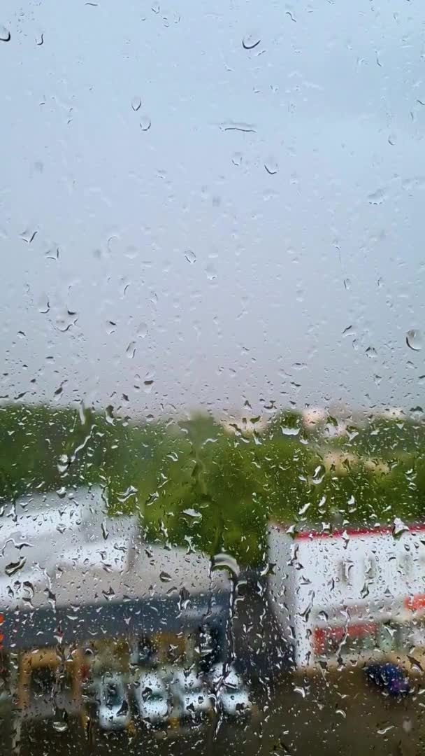 Gotas de chuva em câmera lenta no close-up da janela. Tempo de outono nublado na cidade. Vídeo vertical. — Vídeo de Stock