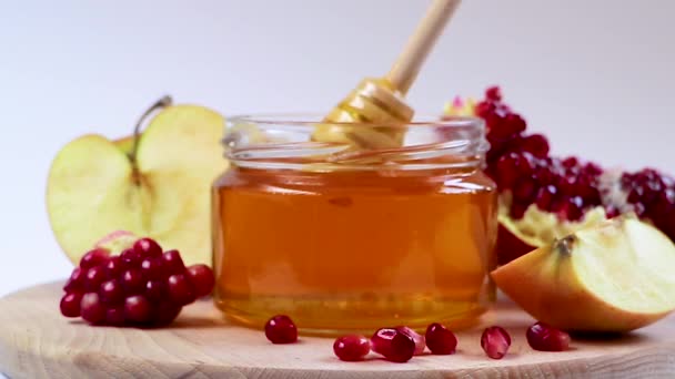 즐거운 로스하샨 나. 새해 첫날은 유대 인들의 명절이다. 하얀 배경의 꿀, 사과, 석류. — 비디오