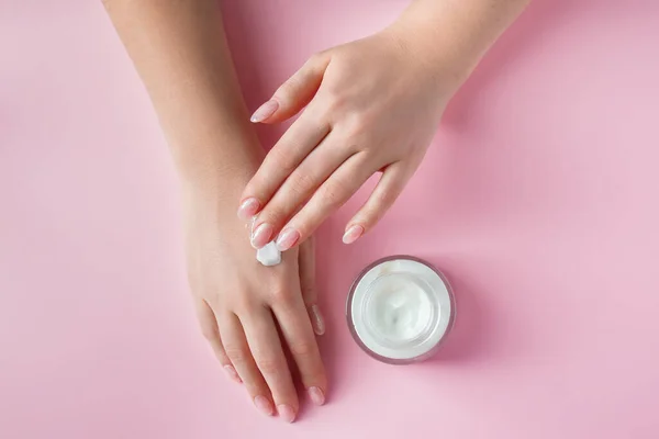 Manos Femeninas Con Una Botella Crema Sobre Fondo Rosa Spa — Foto de Stock