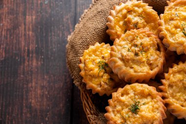 Tahta arka planda taze keklerin olduğu sepet. Sebzeli ve peynirli ev yapımı kekler. Sonbahar mevsimlik yemek tarifi. Kırsal kırsal biçim.