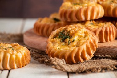 Tahta bir tahtanın üzerinde sebze ve peynirli sıcak lezzetli kekler. Sonbahar mevsimlik yemek tarifi. Sağlıklı beslenme için ev yapımı lezzetli kekler..
