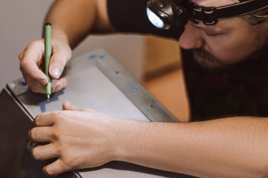 Usta tamirci atölyede metalle çalışır. Erkek işçi bina yapısını belirliyor. Yaşam tarzı, küçük işletmelerin gelişimi.