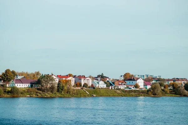 City view on sunny day. Houses stand on the banks of the river. Countryside. — Stock Photo, Image