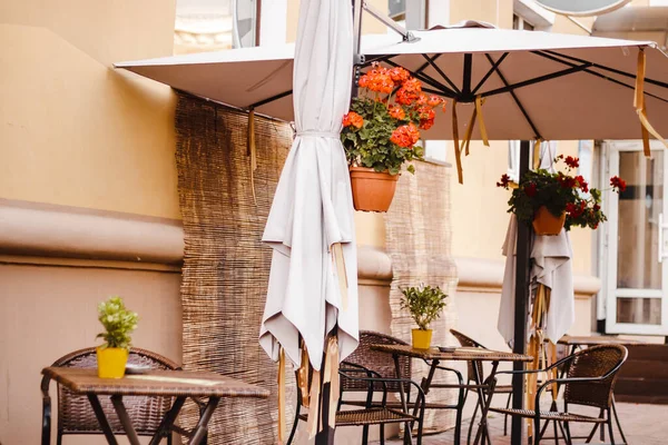 Eski kasabadaki sokak kafesi. Boş masalar ve sandalyeler. Sonbahar şehri manzarası. Eski tarz, modaya uygun nötr renkler.