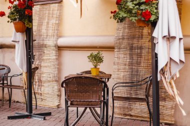 Eski kasabadaki sokak kafesi. Boş masalar ve sandalyeler. Sonbahar şehri manzarası. Eski tarz, modaya uygun nötr renkler.