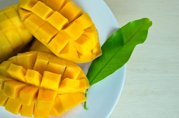 In Scheiben geschnittene reife gelbe Mango mit Blatt — Stockfoto