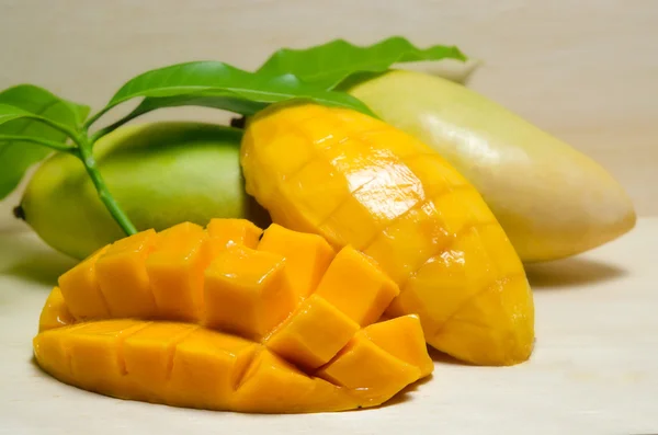 Reife gelbe Mango mit Blatt auf Holzgrund — Stockfoto