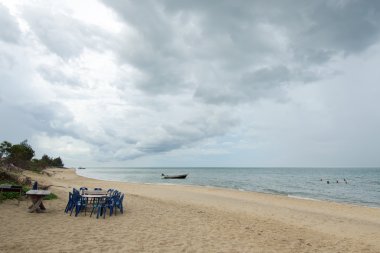 Bulutlu gökyüzü sahilde Barbekü masa ve sandalye