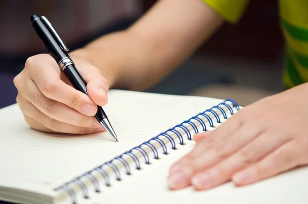 Hand hold a pen and write on a book Stock Picture