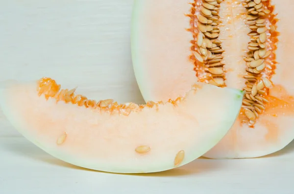 Cantaloupe or Charentais melon with half and seeds on wooden boa