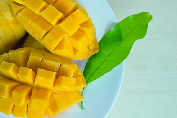 Mango reif mit schön geschnittenen Stücken und Blatt auf dem Teller (andere n — Stockfoto