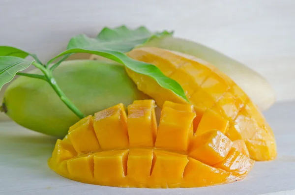 Mango schön geschnitten mit Blatt auf hölzernem Hintergrund (andere Namen von — Stockfoto