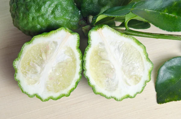 Bergamot fruit met leaf op houten plank — Stockfoto