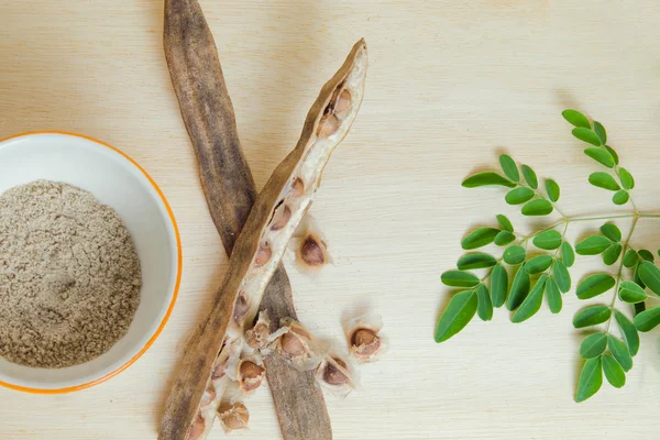 Moringa smerigliato foglia e seme su sfondo bordo di legno — Foto Stock