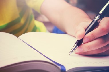 Bir kalem ve bir kitap sabah ışık ile filtre ile etkinlik yazmak