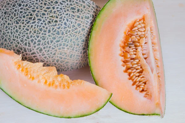 Sliced melon with seed on wooden board