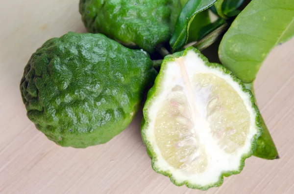 Bergamot fruit met leaf op houten plank — Stockfoto