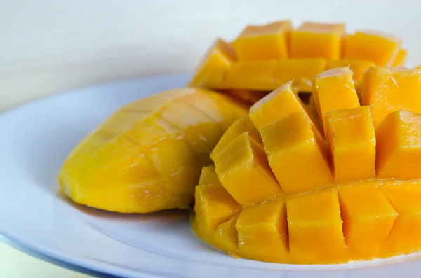 Mango fint skivad på vit platta — Stockfoto