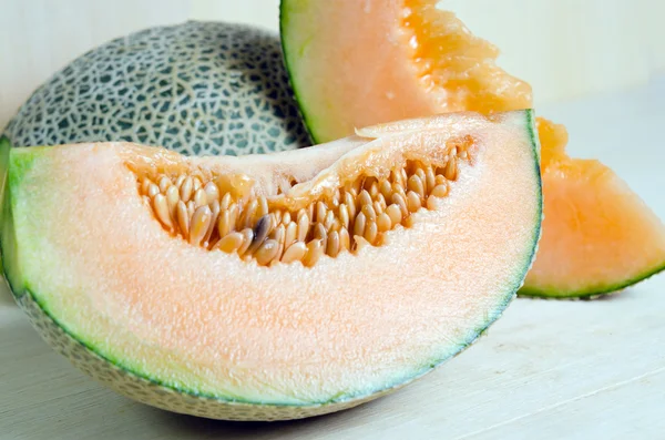 Cucumis melo oder Melone mit Hälfte und Samen auf Holzteller (andere — Stockfoto