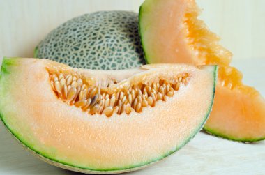 Cucumis melo veya kavun yarısı ve ahşap plaka (diğer tohum ile