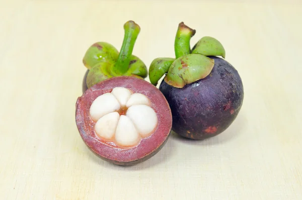Mangosteen fruit with half cross section isolated on wooden boar — Stock Photo, Image
