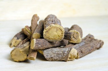 Ahşap arka plan üzerinde izole meyan kökü veya meyan kökü kök sopa