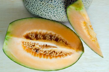 Kavun veya Charentais kavun yarısı ve tohumlar üzerinde ahşap boa