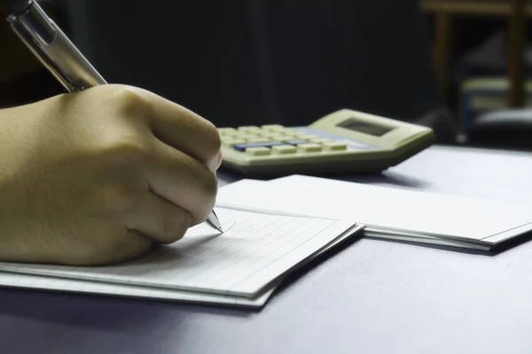 Hand calculates number with calculator background — Stock Photo, Image