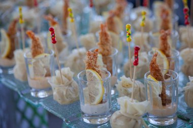 Şeffaf bardaklarda soslu ve limonlu gevrek karidesler.