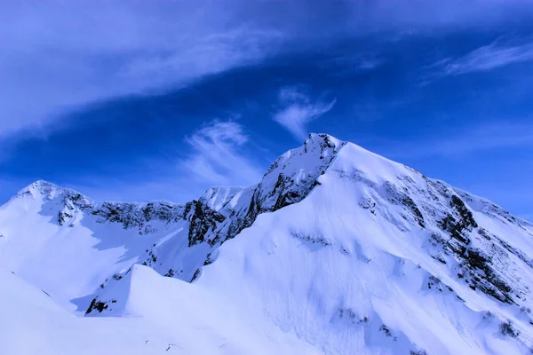 snow mountain peak in blue cloudy sky