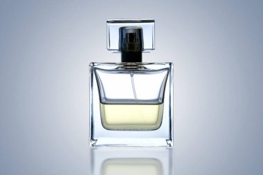 Sade arka planda yansıması olan bir şişe tuvalet suyu.