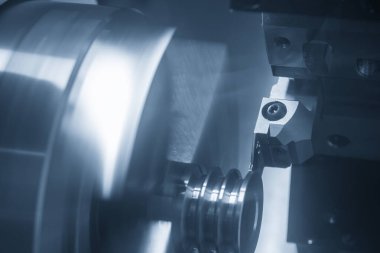 CNC torna makinesi, metal makara parçalarını kesiyor. CNC dönüşüm makinesinin yüksek teknolojili metal işlemesi .