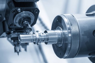 Metal şaft parçalarını kesen makinelerin işletilmesi. CNC çoklu görev makinesinin yüksek teknolojili otomotiv parçası üretim süreci.