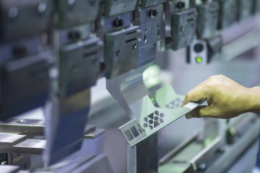 Teknisyenle hidrolik bükme makinesi operasyonu. Teknisyen ile fren bükme makinesinin yaptığı levha metal üretim işlemi..