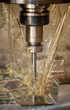 CNC değirmen makinesinin dikey görüntüsü küf parçalarını yağ soğutma metoduyla kesiyor. CNC makine merkezi tarafından üretilen kalıp ve ölüm süreci.