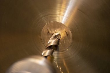 Torna makinesindeki sondaj işleme pirinç plakasının yakın çekim sahnesi. Yüksek teknolojili metal dönüşüm makinesinde çalışıyor..